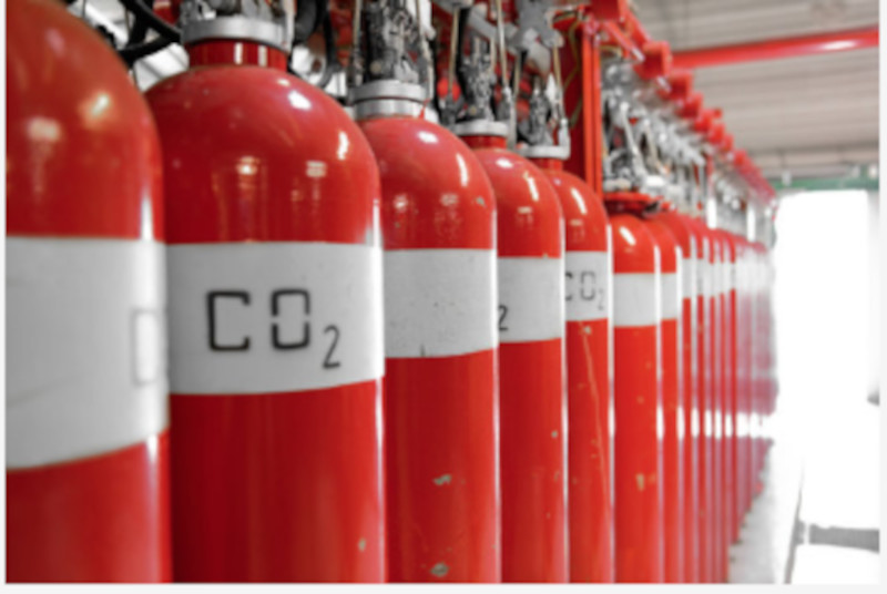 Fabricación de un conjunto de extintores rojos de CO2 en una nave industrial