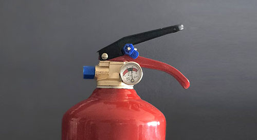 Palanca del extintor Primer plano de la palanca de un extintor de polvo ABC, resaltando su importancia en la seguridad contra incendios en extintores Coslada.