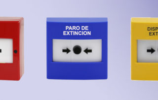 Tres tipos de pulsadores de alarma de incendio.